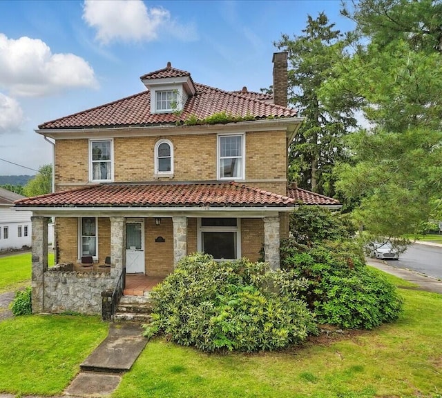639 Iron St, Lehighton, PA 18235 - view of front of house with a chimney, a tiled roof, covered porch, a front yard, and brick siding