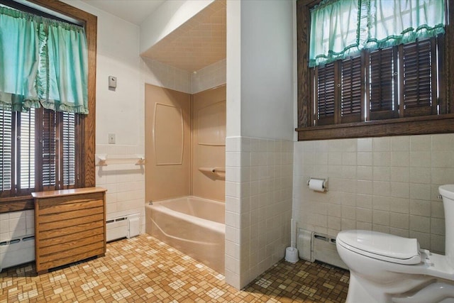 639 Iron St, Lehighton, PA 18235 - bathroom featuring tile walls, a baseboard radiator, plenty of natural light, a tub to relax in, and a wainscoted wall