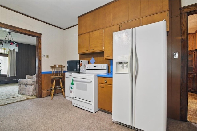 639 Iron St, Lehighton, PA 18235 - kitchen with white appliances, light carpet, brown cabinetry, wood walls, and crown molding