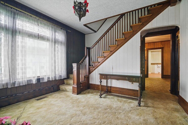 639 Iron St, Lehighton, PA 18235 - staircase with carpet flooring, a textured ceiling, and wooden walls