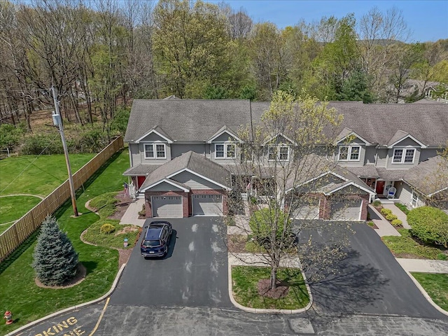 view of front of property featuring a front lawn, aphalt driveway, and fence