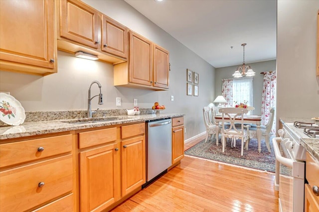 kitchen featuring stainless steel dishwasher, a sink, light wood-style flooring, and white gas range