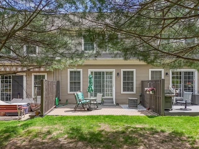 rear view of property featuring a lawn, a patio area, and central air condition unit