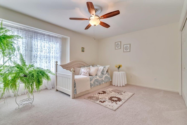 carpeted bedroom featuring a ceiling fan and baseboards