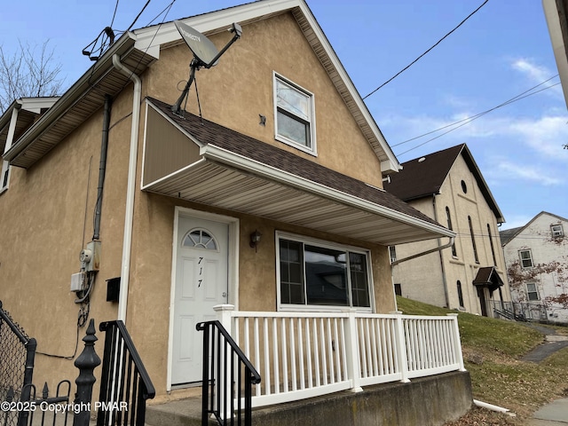 view of front of property featuring fence and stucco siding