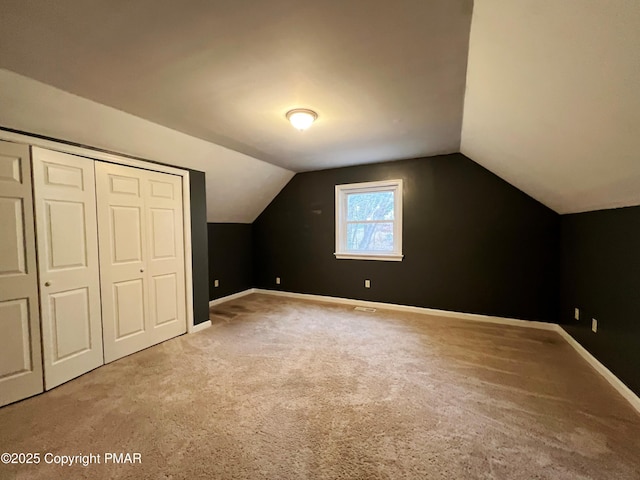 bonus room with lofted ceiling, baseboards, and carpet flooring