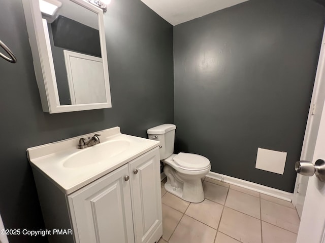 bathroom with toilet, tile patterned flooring, baseboards, and vanity