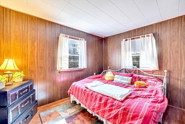 bedroom featuring wood walls and wood finished floors