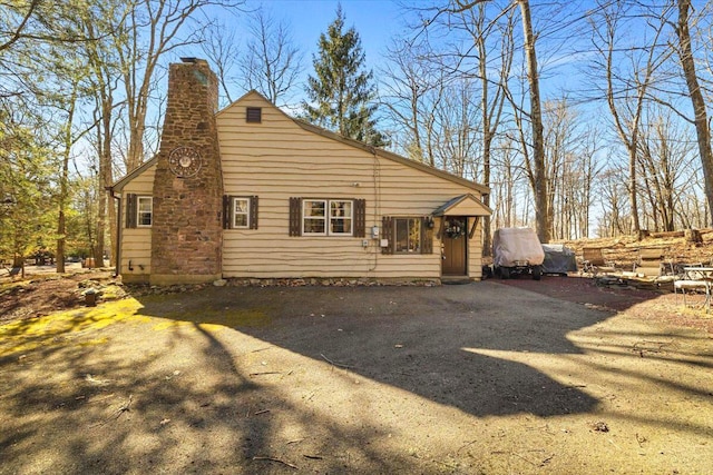 exterior space featuring a chimney and driveway