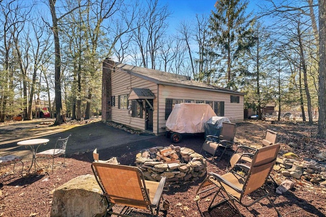 view of side of property featuring a fire pit and a chimney