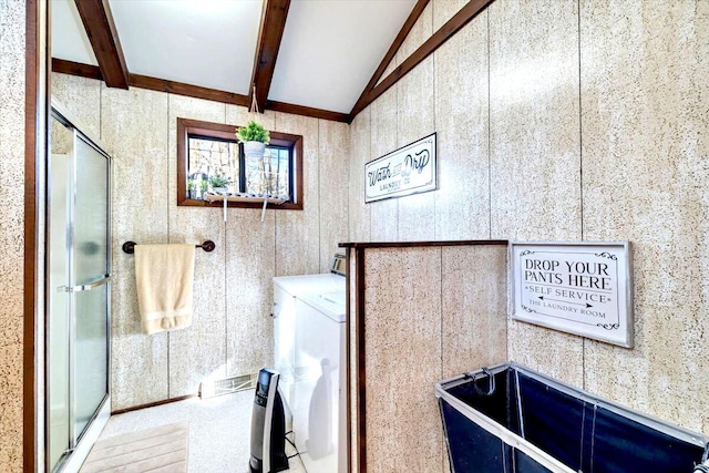 bathroom featuring washing machine and clothes dryer, a shower stall, and lofted ceiling with beams