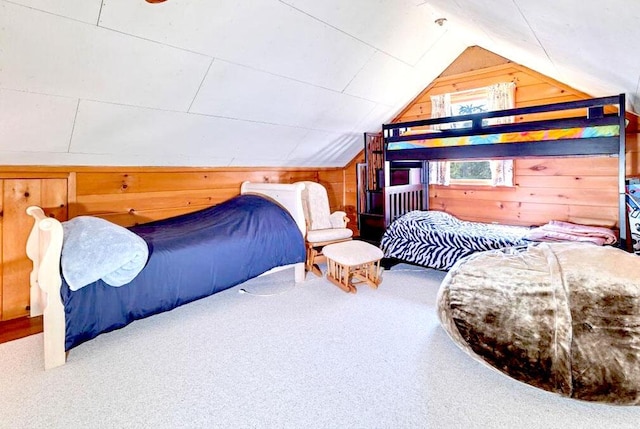 carpeted bedroom featuring lofted ceiling and wood walls