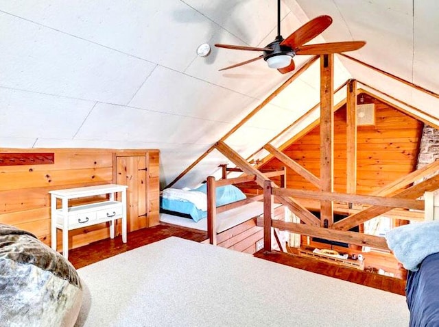 bedroom featuring lofted ceiling and wooden walls