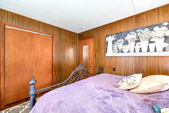 bedroom with a closet and wooden walls