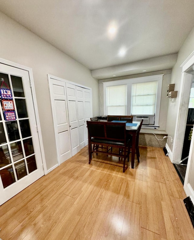 dining space featuring light wood-type flooring and baseboards