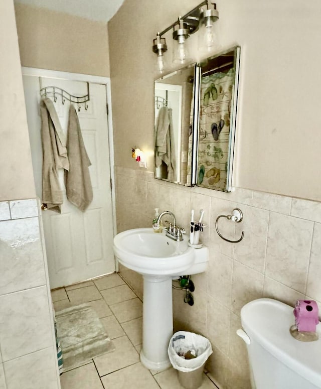 bathroom featuring tile patterned floors, tile walls, and wainscoting