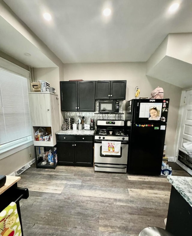 kitchen featuring baseboards, recessed lighting, wood finished floors, black appliances, and dark cabinets