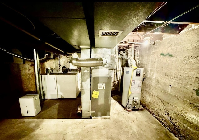 utilities with gas water heater, washing machine and dryer, and visible vents