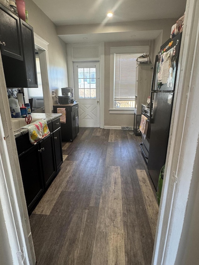 kitchen with dark cabinetry, light countertops, dark wood-style flooring, and stainless steel range with gas cooktop