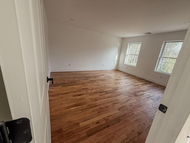 unfurnished room with dark wood-style floors, recessed lighting, visible vents, and baseboards