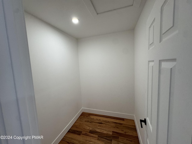 interior space featuring attic access, baseboards, and dark wood finished floors