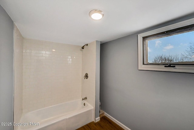 full bath featuring shower / washtub combination, baseboards, and wood finished floors