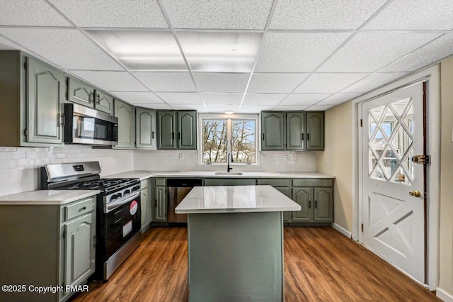 kitchen featuring appliances with stainless steel finishes, dark wood-style flooring, a sink, and green cabinets