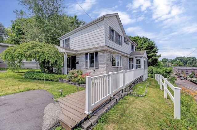 view of side of property featuring a yard and stone siding