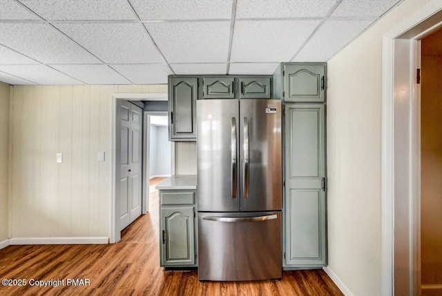 kitchen with dark wood finished floors, green cabinets, and freestanding refrigerator