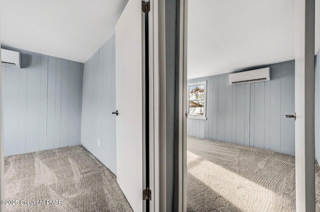 hallway featuring an AC wall unit and carpet flooring