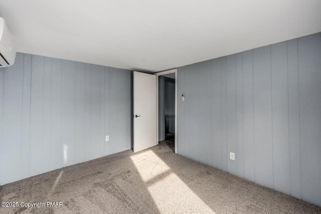 carpeted spare room featuring a wall mounted air conditioner