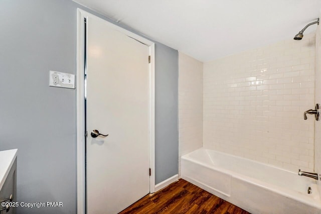 full bath featuring vanity, shower / bathing tub combination, wood finished floors, and baseboards