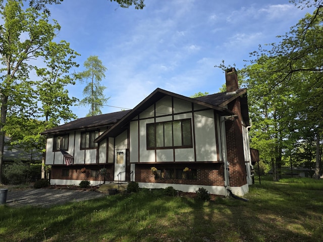 234 Saturn Dr, Bushkill, PA 18324 - view of front of home with brick siding, a chimney, and a front lawn