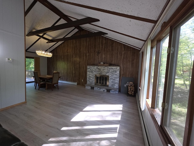 234 Saturn Dr, Bushkill, PA 18324 - unfurnished living room with a baseboard heating unit, beam ceiling, wood walls, a chandelier, and wood finished floors
