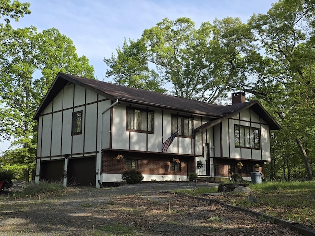 234 Saturn Dr, Bushkill, PA 18324 - view of home's exterior with a chimney, board and batten siding, and brick siding