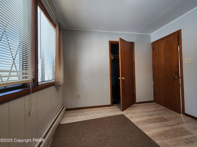 234 Saturn Dr, Bushkill, PA 18324 - unfurnished bedroom with light wood-type flooring, ornamental molding, baseboard heating, a closet, and baseboards