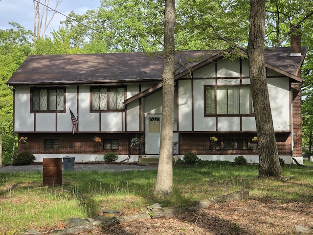234 Saturn Dr, Bushkill, PA 18324 - view of front of home with brick siding, a shingled roof, stucco siding, and a chimney