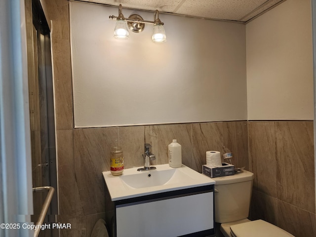 234 Saturn Dr, Bushkill, PA 18324 - bathroom featuring toilet, vanity, and a wainscoted wall