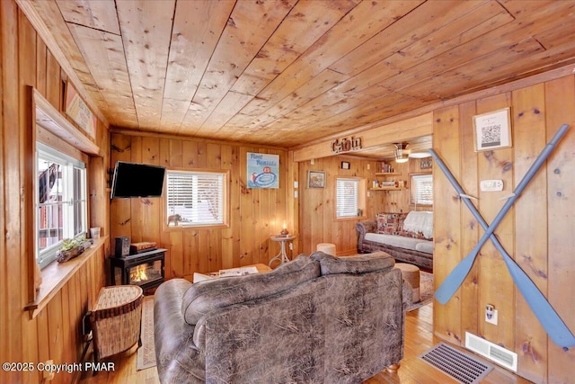 living room with wooden walls, light hardwood / wood-style floors, and wooden ceiling