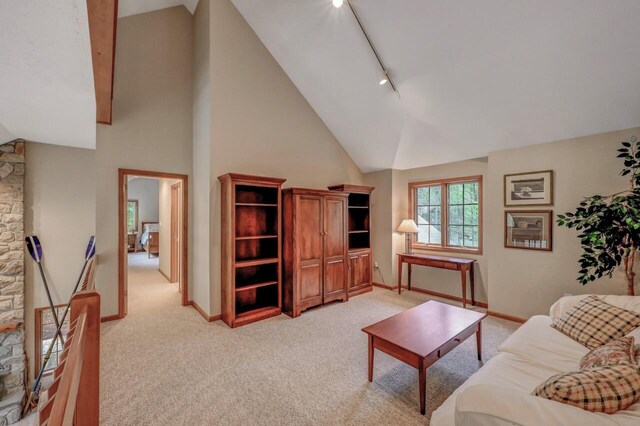 3110 Tall Timber Lake Rd, Pocono Pines, PA 18350 - living room featuring light carpet, track lighting, high vaulted ceiling, and baseboards