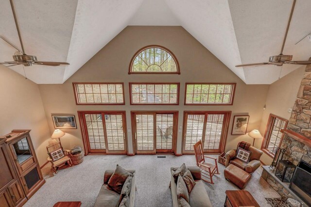 3110 Tall Timber Lake Rd, Pocono Pines, PA 18350 - living room with a ceiling fan, carpet flooring, high vaulted ceiling, and a stone fireplace