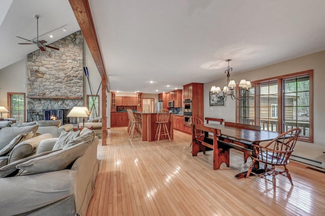3110 Tall Timber Lake Rd, Pocono Pines, PA 18350 - dining area featuring light wood finished floors, ceiling fan, a chandelier, a stone fireplace, and vaulted ceiling