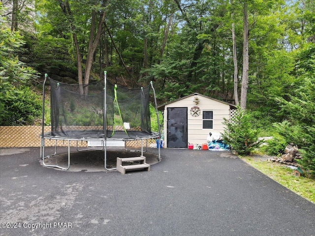 exterior space featuring a shed, a trampoline, and an outdoor structure