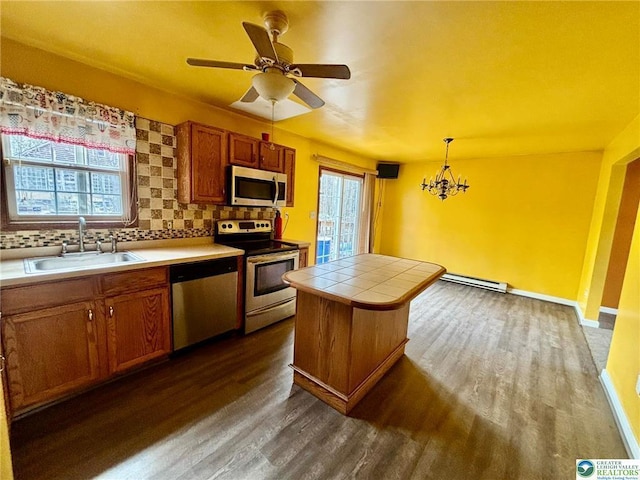 kitchen featuring a sink, tile countertops, decorative backsplash, appliances with stainless steel finishes, and dark wood-type flooring