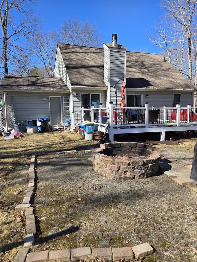 rear view of house with a chimney and a wooden deck