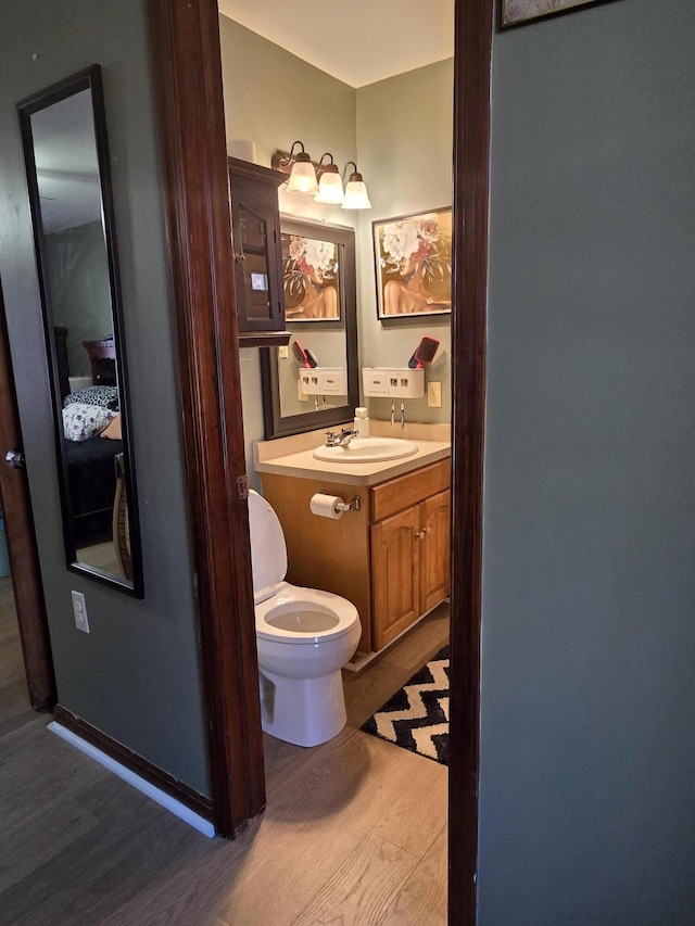 bathroom with vanity, toilet, and wood finished floors