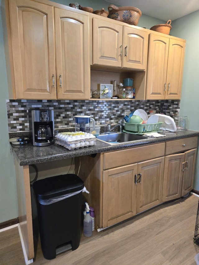 kitchen featuring light wood-style floors, dark countertops, light brown cabinets, and decorative backsplash