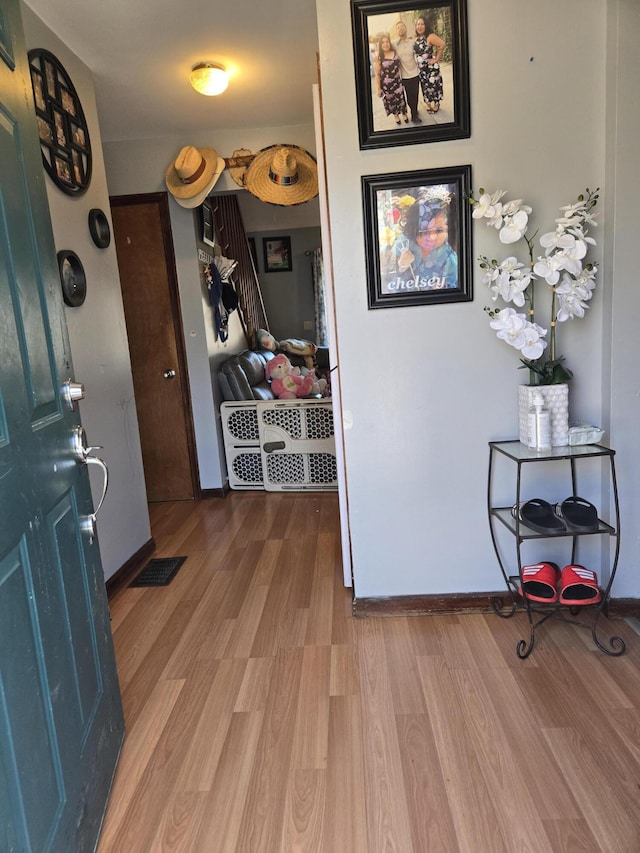 entrance foyer featuring visible vents, stairway, baseboards, and wood finished floors