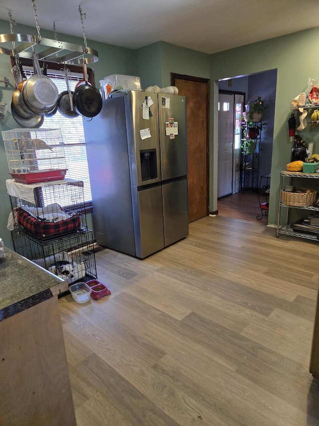 kitchen with wood finished floors and stainless steel fridge