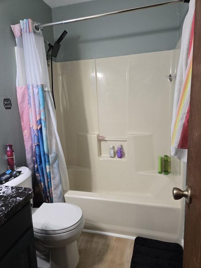 full bathroom with toilet, shower / bathtub combination with curtain, wood finished floors, and vanity